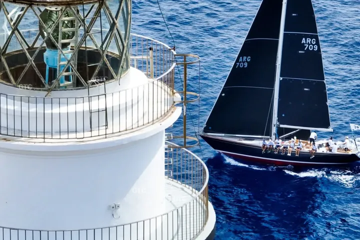 Velero de competición junto al faro de la entrada del puerto de Mahón · Aeroview.es